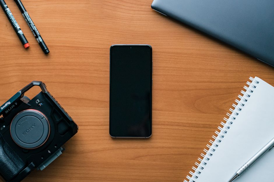 Vintage Rolodex sits beside a sleek, modern smartphone on a clean desk, visually representing the technological shift from...